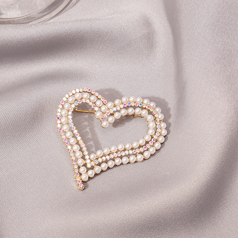 A French romantic and sweet heart-shaped brooch with a girlish heart, studded with pearls in contrasting colors, and featuring an exaggerated large peach-shaped heart badge for a woman details Picture