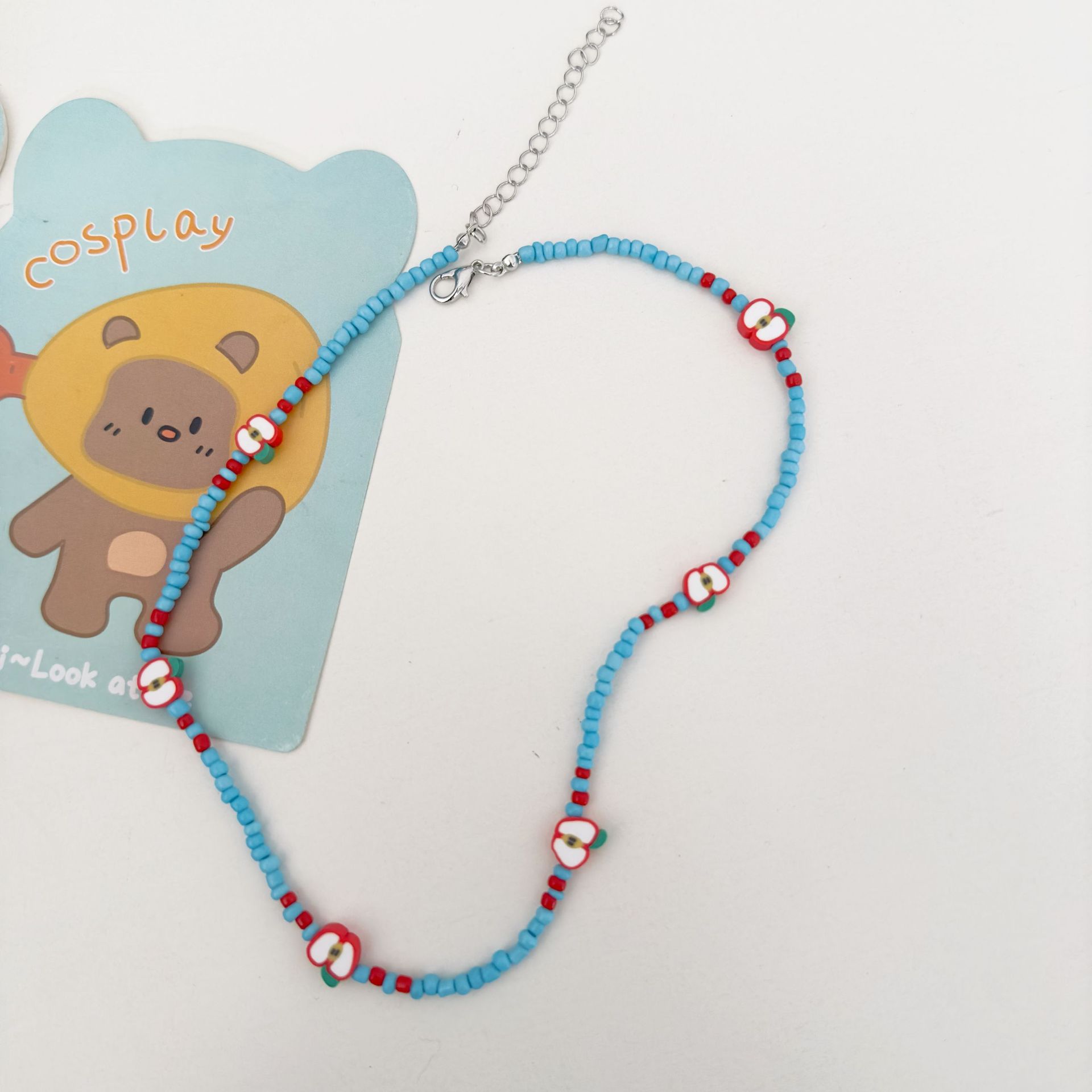 A fresh Japanese and Korean rice beaded soft clay apple necklace with a sweet and forest style, a niche design, and a collarbone chain for a young girl details Picture