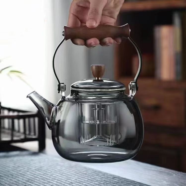 This is a large-capacity household steaming and boiling teapot with a handle. It is made of smoke grey wood and has a starry sky handle. It is a glass boiling teapot full figure