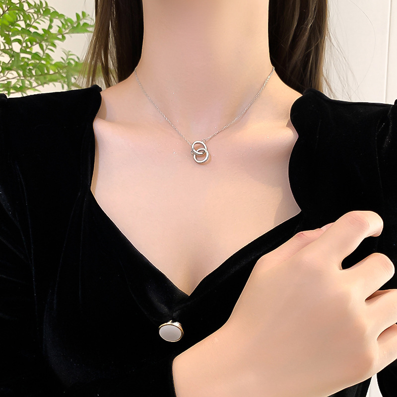 A silver, simple, slightly diamond-encrusted double-ring necklace with a unique feminine charm and a light luxury collarbone chain. It features a distinctive circular design pendant details Picture