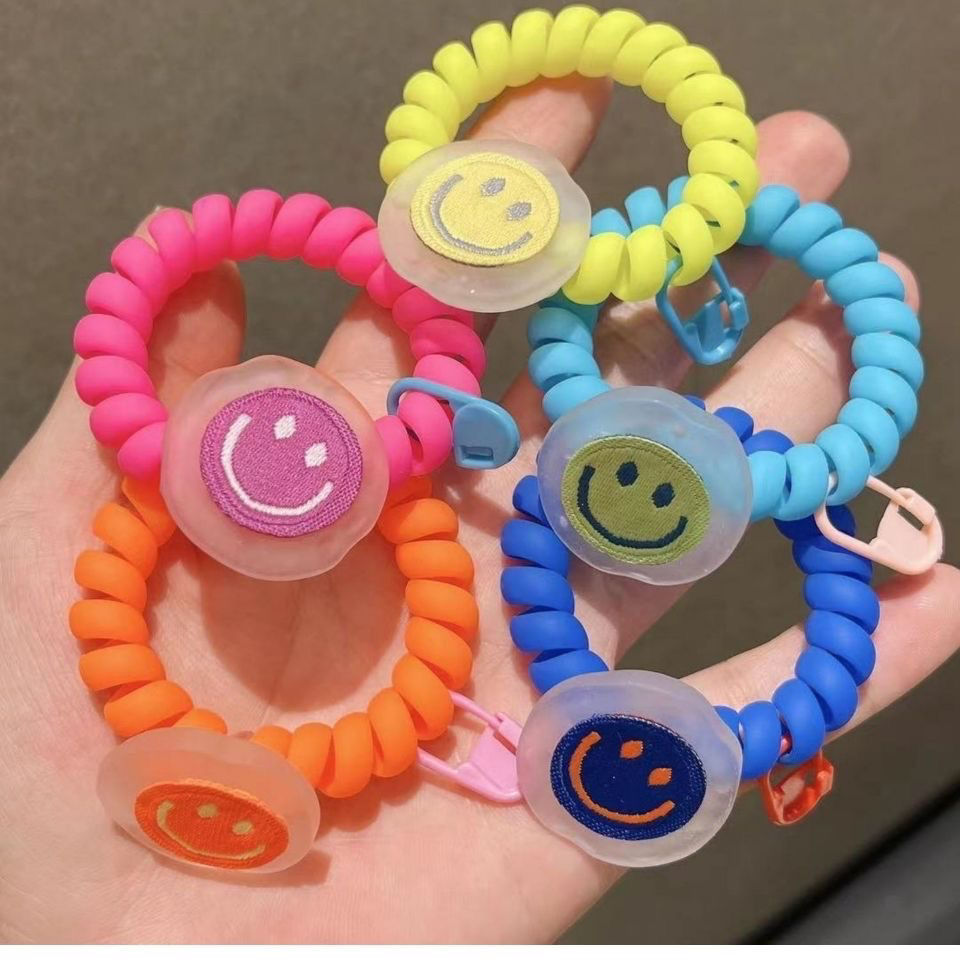 In Dongdaemun, South Korea, there is a matte texture smiley face telephone line hair band. The girl has a fluorescent color fashionable hair tie and a bun headband full figure