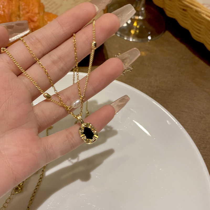 A simple black oval pendant double-layer pearl necklace with a European and American style, exuding a sense of sophistication and versatility. It is a stylish collarbone chain accessory full figure