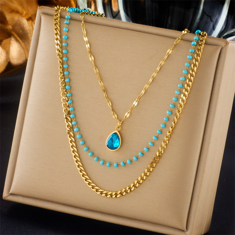 A high-end retro titanium steel necklace with a multi-layer stacked chain water drop pendant and a unique European and American style full figure