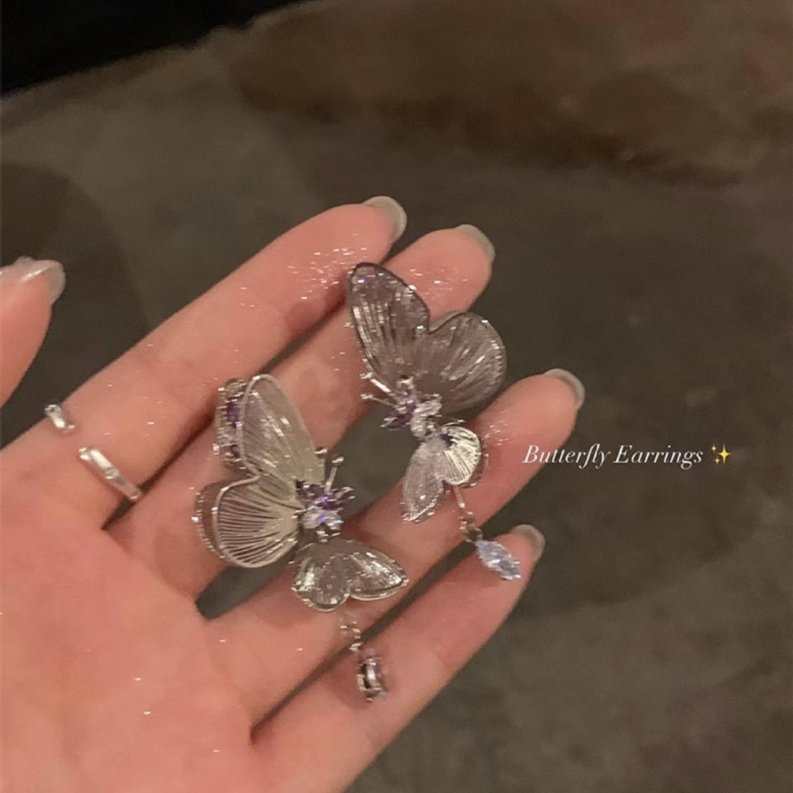 The ethereal purple zirconia dynamic hollowed-out butterfly unique earrings exude a light luxury and high-end feel for women. The niche stud earrings are exquisite details Picture