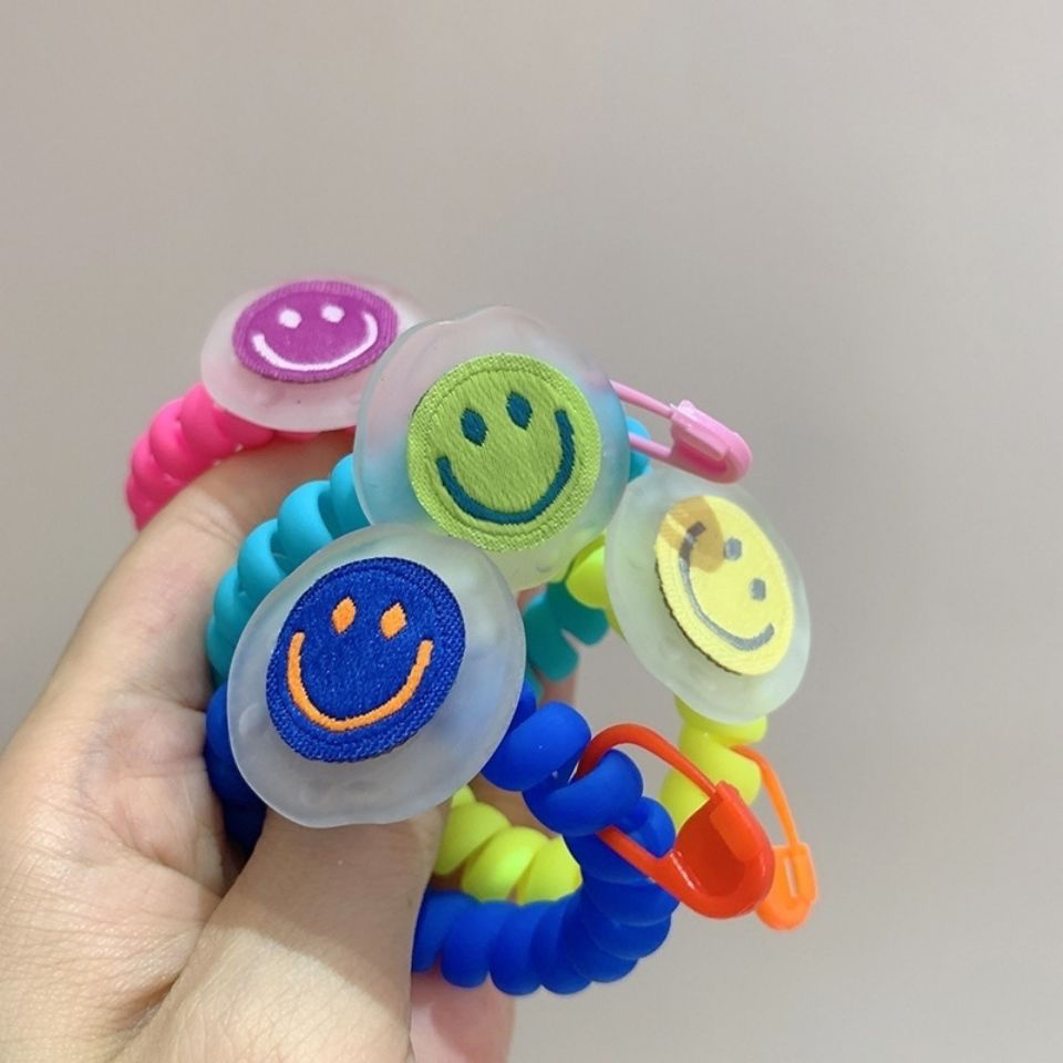 In Dongdaemun, South Korea, there is a matte texture smiley face telephone line hair band. The girl has a fluorescent color fashionable hair tie and a bun headband details Picture