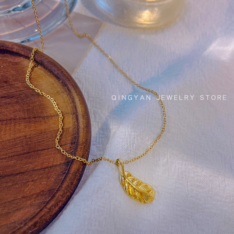 Golden small feather pendant titanium steel necklace for women in Instagram style, simple and individual, real gold electroplated collarbone chain, versatile accessory full figure