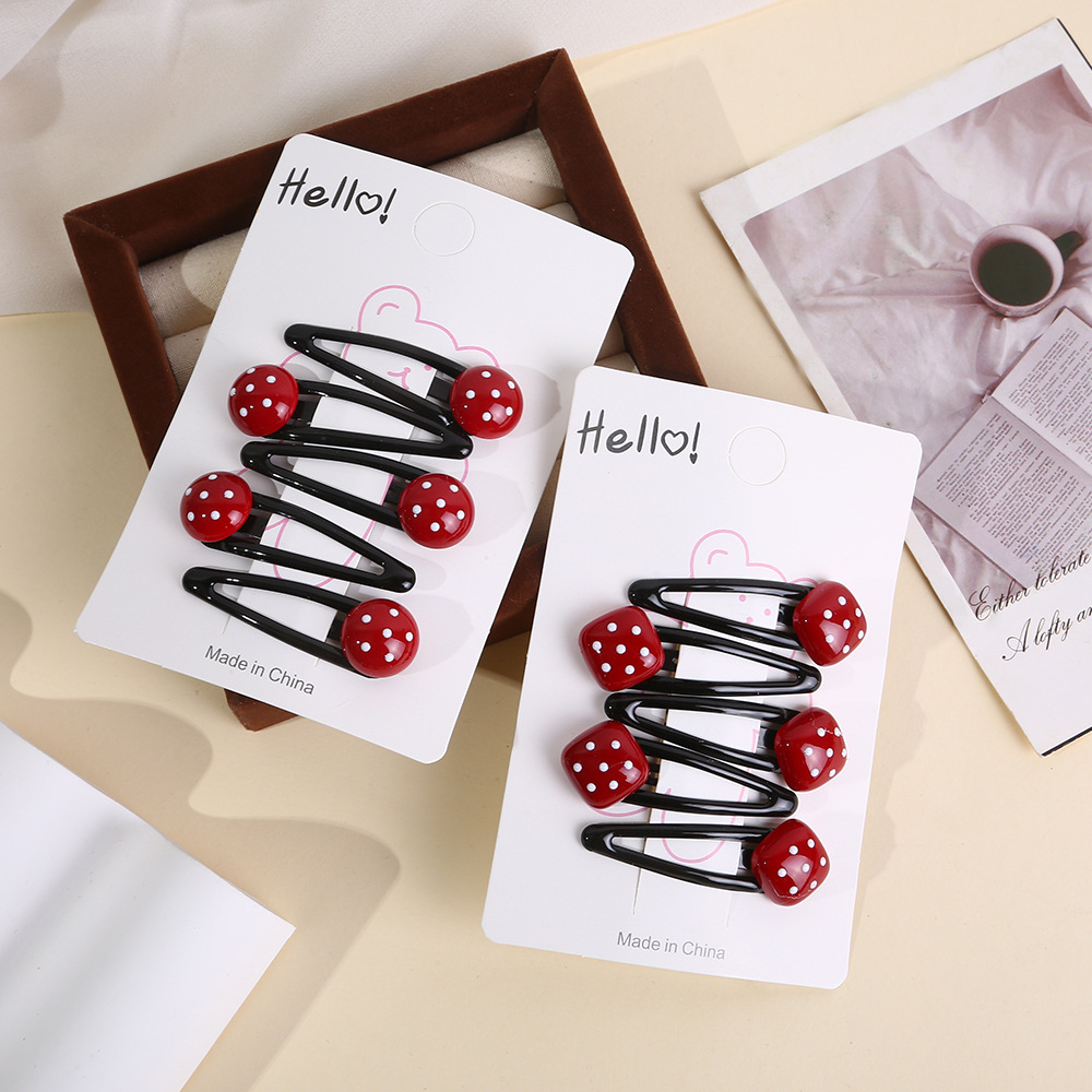 The little girl has a bangs on the side of her forehead with a red Ankela hair clip, a children's polka dot heart-shaped bb hair clip and a hair accessory Specification drawing