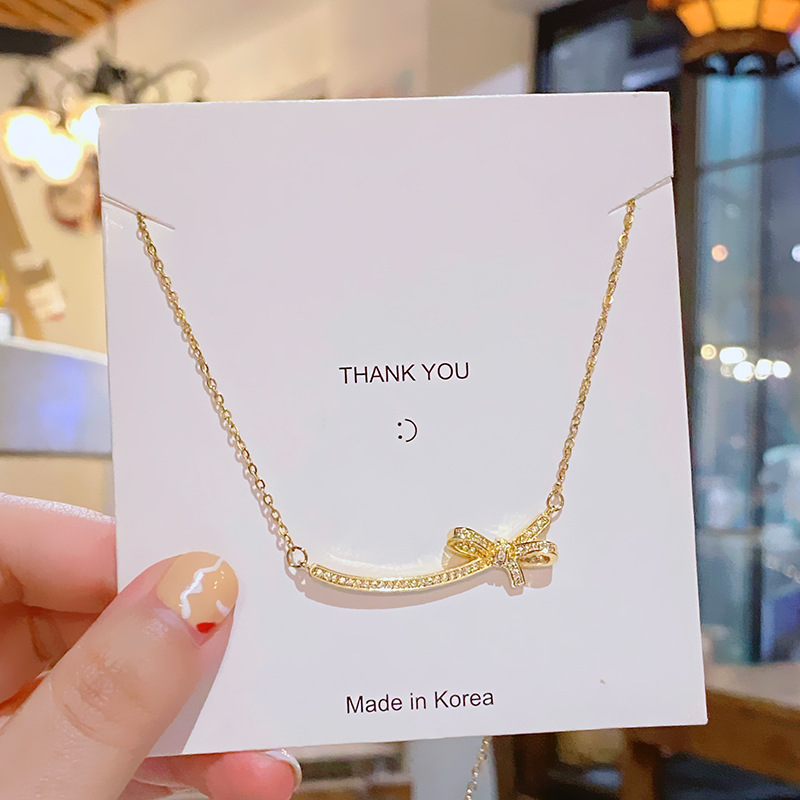 Elegant and luxurious, full diamond zircon smiling bow necklace, a niche design for women with a sense of high-end titanium steel collarbone chain wholesale Application Scenario