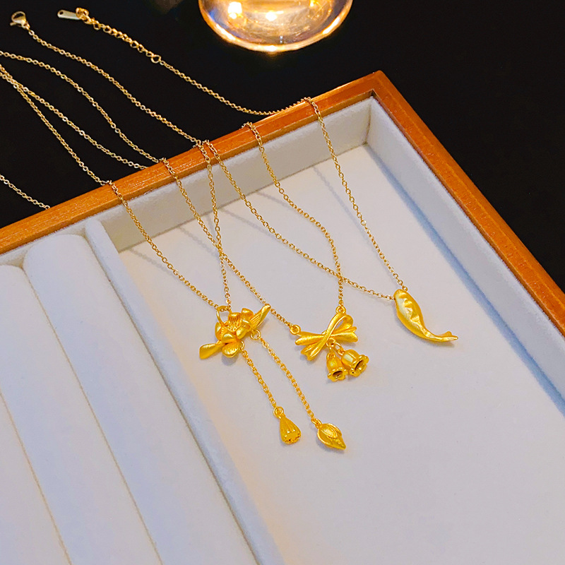 A genuine gold electroplated matte gold titanium steel necklace with a unique and light luxury feel for women. It features a lotus bow and tassel collarbone chain, making it a versatile accessory full figure