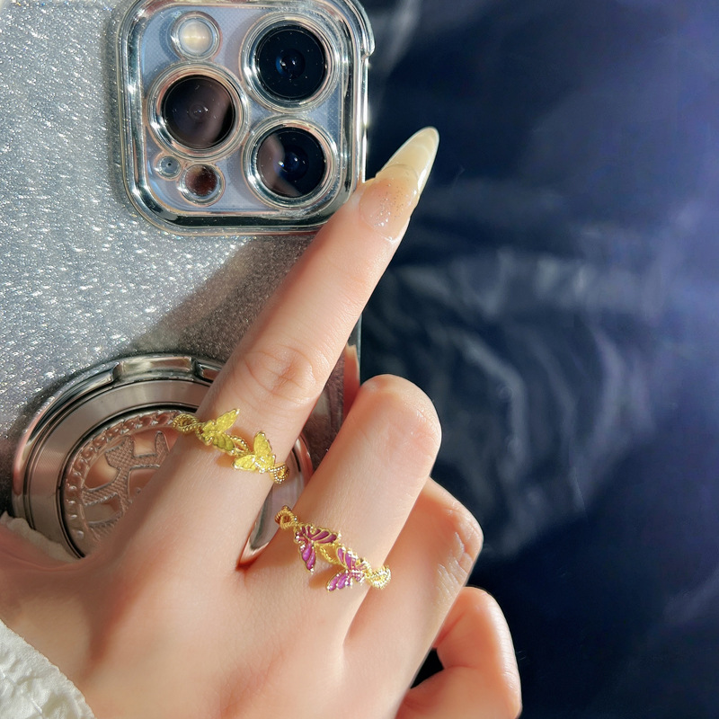 A golden double butterfly opening ring with a purple drip glaze for women, featuring a light luxury and niche design, is exquisite and sweet. It is a trendy ring accessory full figure