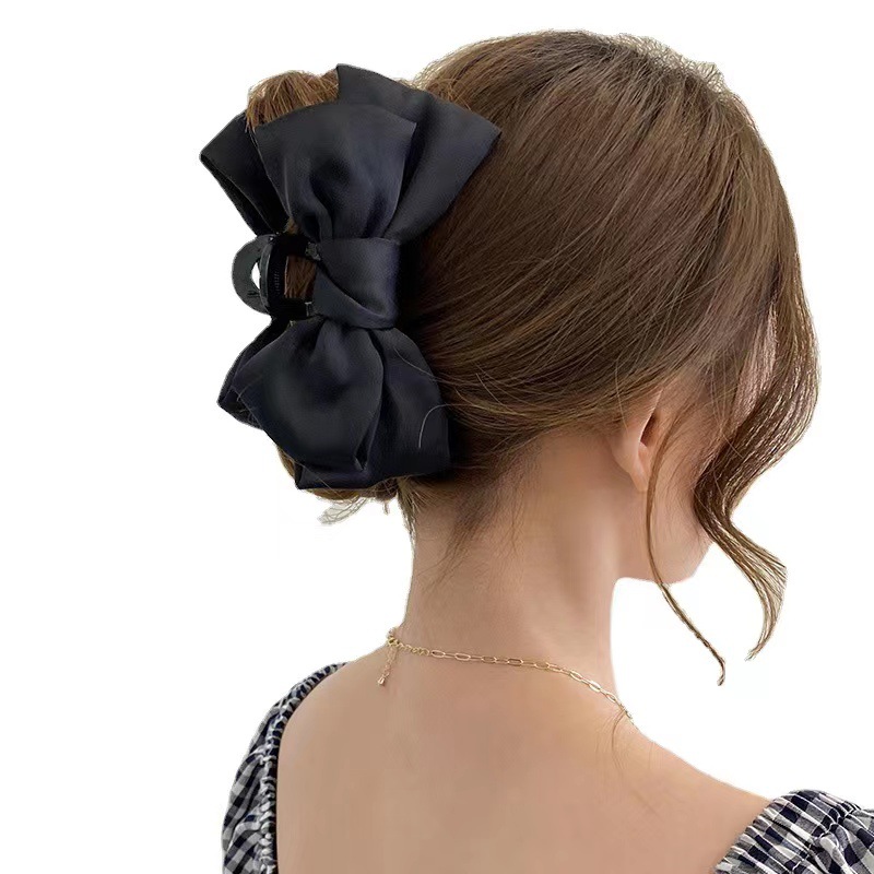 A black double-sided Korean-style large bow hair accessory with a hairpin on the back of a woman's head Item Picture
