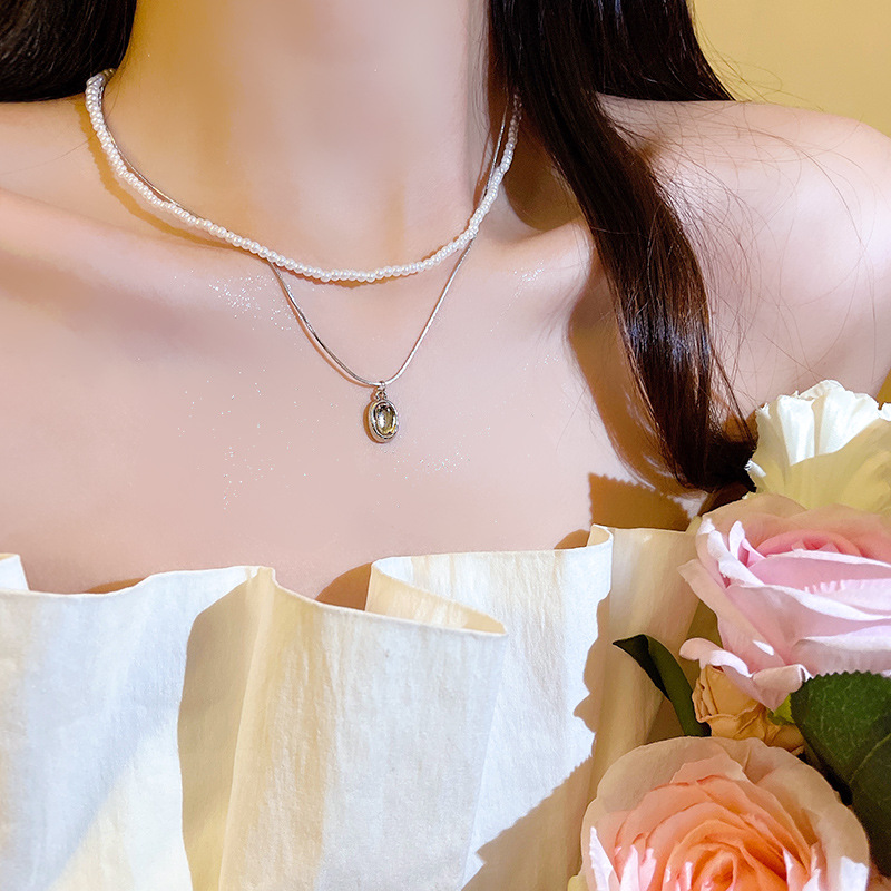 The light luxury French double-layer pearl pendant necklace exudes a sense of sophistication for women. The layered collarbone chain is a popular and trendy necklace accessory full figure