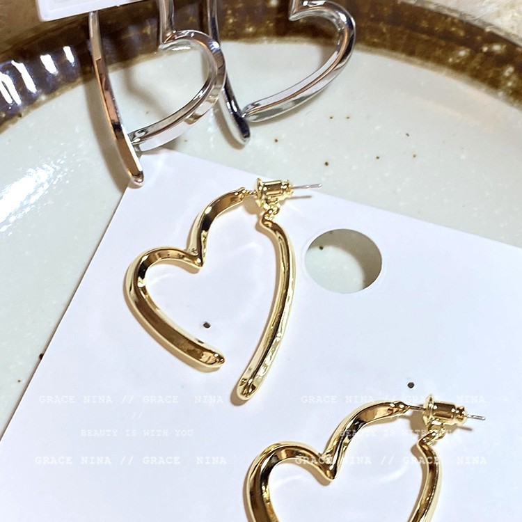 The cross-shaped heart-shaped earrings with a niche design sense exude a simple yet sophisticated charm and a cold, individualistic style. They are worn with stud earrings on the front and back details Picture