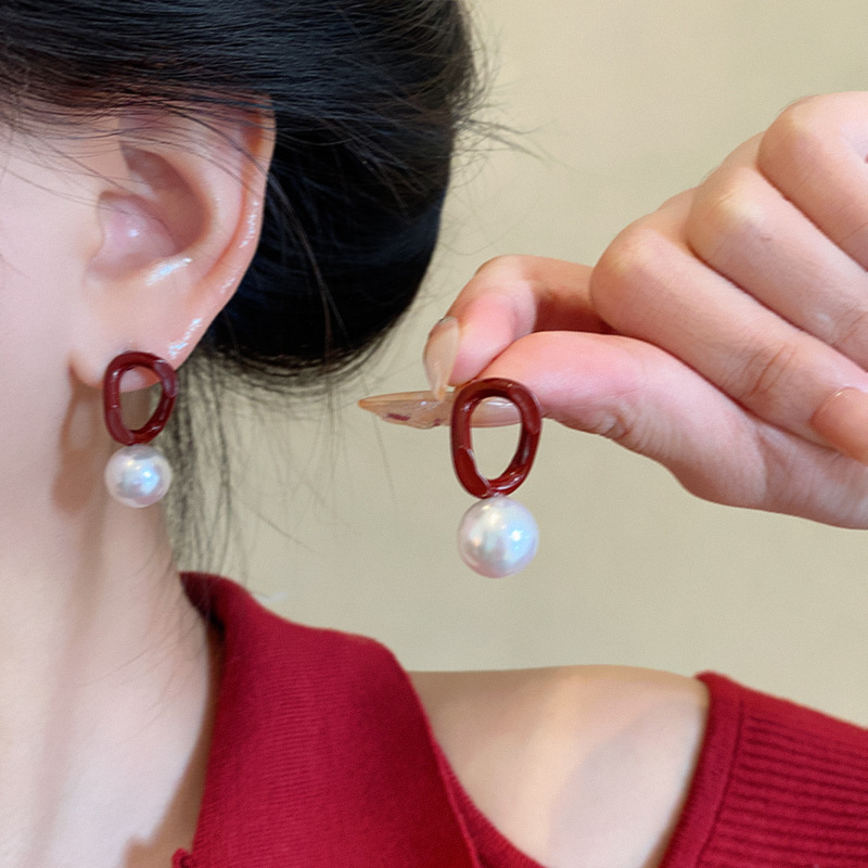 The Ankela red pearl contrasting color earrings for autumn and winter are versatile for women, with a retro and high-end feel. The commuter stud earrings are a unique and popular accessory details Picture
