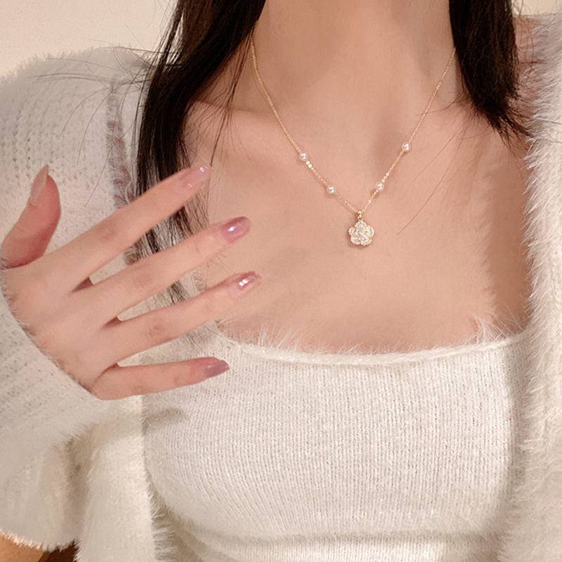 The light luxury and niche camellia pearl necklace is fashionable and versatile. The collarbone chain exudes a sense of sophistication and is a popular and trendy sweater chain accessory full figure