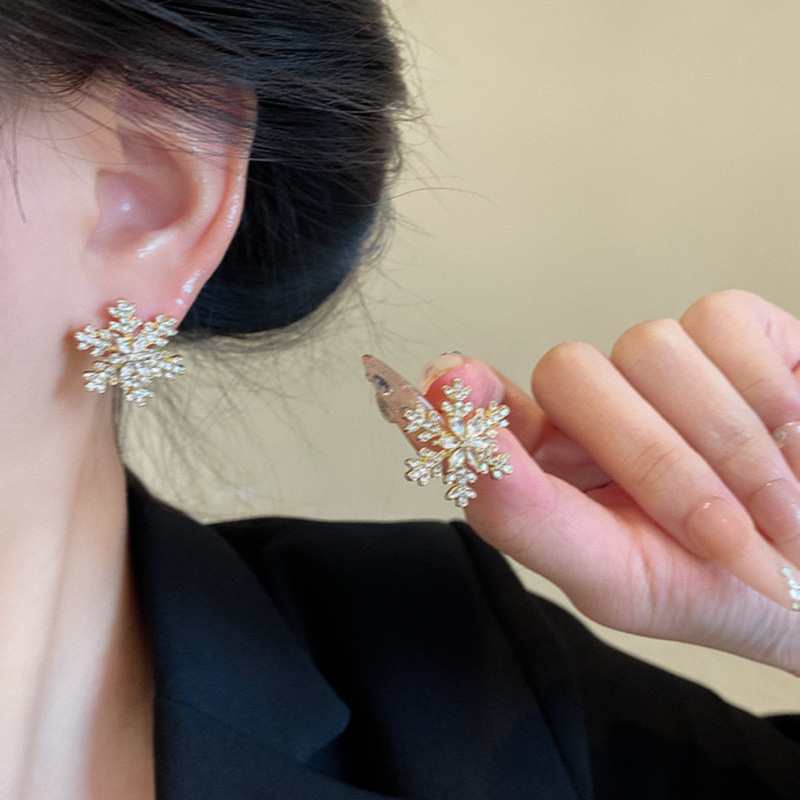 Golden snowflake stud earrings, a popular autumn and winter high-end earring for women, are light luxury, niche and exquisite Christmas earrings. New style for 2024 details Picture