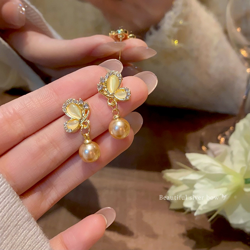 French light luxury style, champagne-colored pearl butterfly stud earrings, niche design, high-end feel, cat-eye earrings, versatile accessories full figure