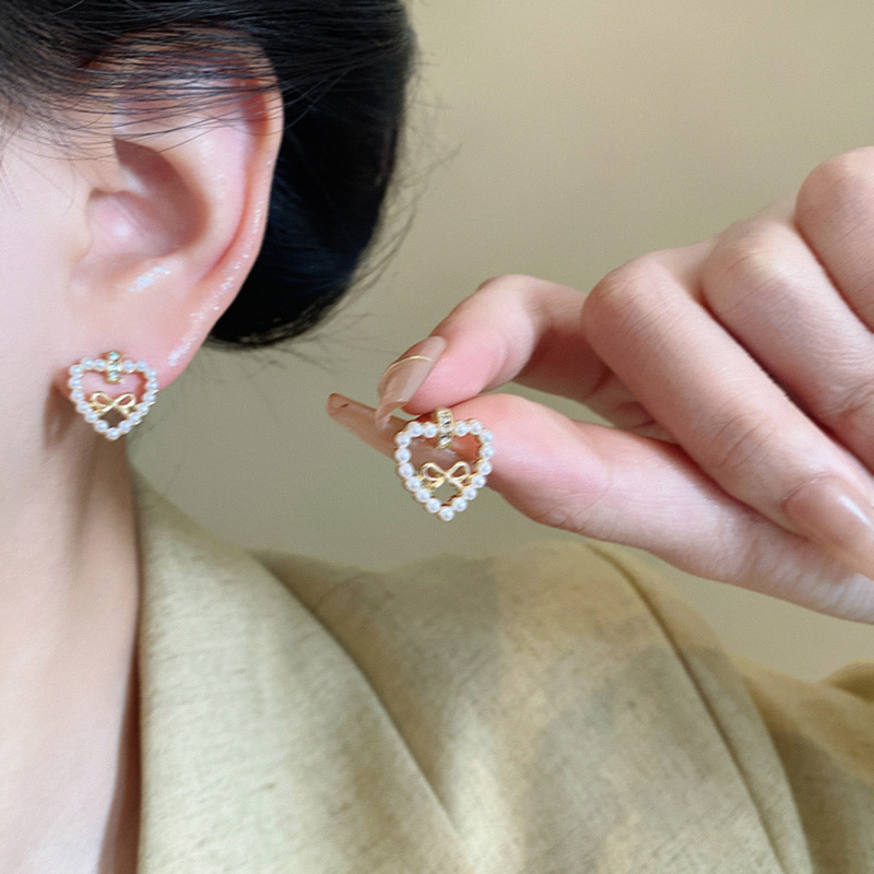 Light luxury hollowed-out heart-shaped bow pearl earrings, versatile for women, high-end and elegant stud earrings, 2025 new style earrings details Picture