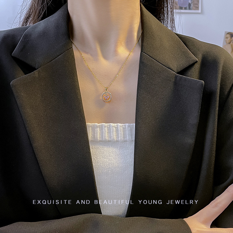 A high-end Japanese and Korean diamond-encruted round geometric titanium steel necklace with a unique and light luxury design for women, featuring an E-letter pendant accessory Application Scenario
