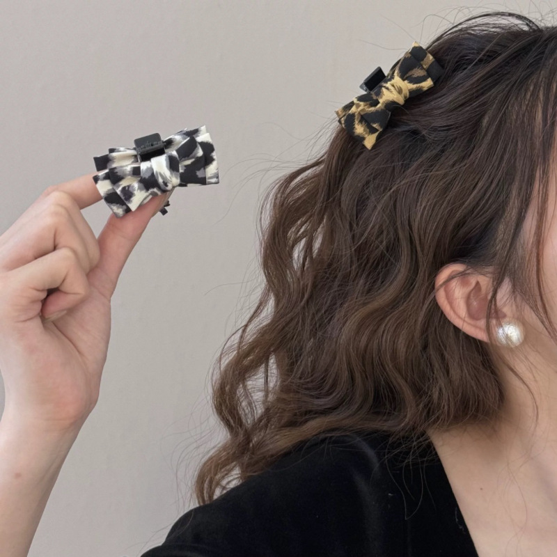 The new old-fashioned leopard print large bow hair clip has a feminine feel. It features a small claw clip at the back of the head and a half-tied headpiece, hairpin and hair accessory details Picture