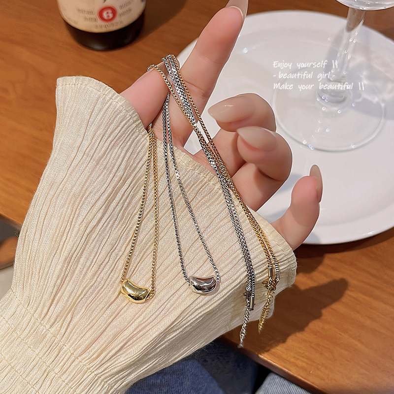The new Korean Golden bean pendant titanium steel necklace for women in 2023 features a trendy and high-end design with a versatile collarbone chain details Picture