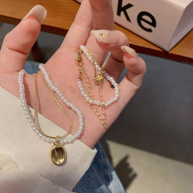 The light luxury French double-layer pearl pendant necklace exudes a sense of sophistication for women. The layered collarbone chain is a popular and trendy necklace accessory details Picture