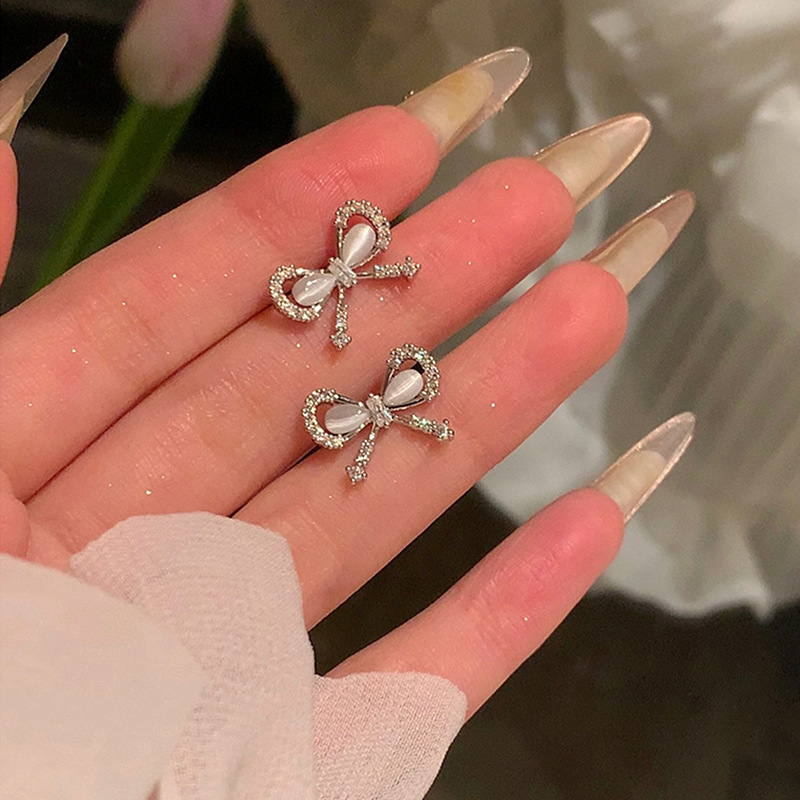Zirconium-inlaid cat's eye stone bow earrings for women, a light luxury, niche and high-end look, cold and elegant style, a popular earpiece on the Internet full figure
