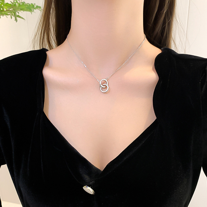 A silver, simple, slightly diamond-encrusted double-ring necklace with a unique feminine charm and a light luxury collarbone chain. It features a distinctive circular design pendant Application Scenario