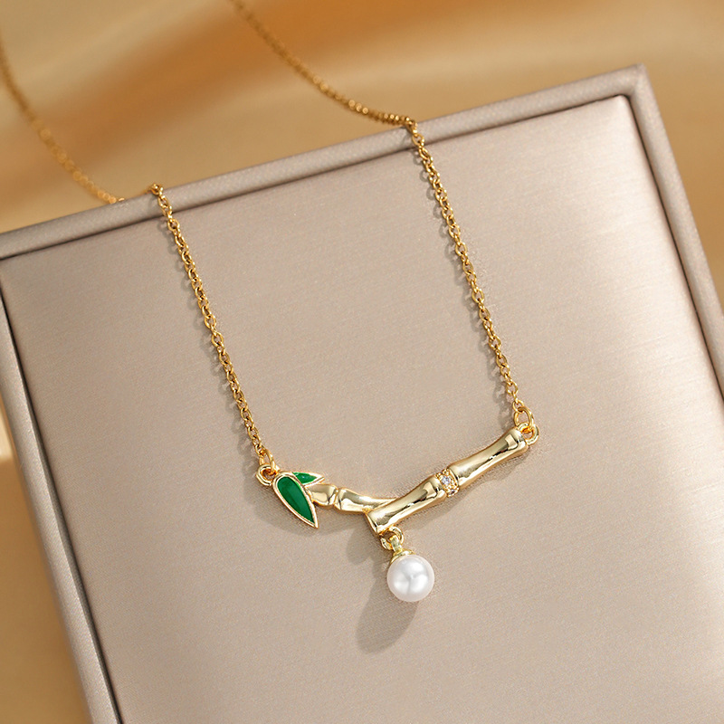 This is a genuine gold electroplated small bamboo joint titanium steel necklace with a fashionable and light luxury design. It features a pearl pendant and a collarbone chain, making it a versatile accessory full figure