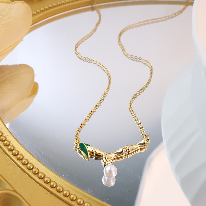This is a genuine gold electroplated small bamboo joint titanium steel necklace with a fashionable and light luxury design. It features a pearl pendant and a collarbone chain, making it a versatile accessory details Picture