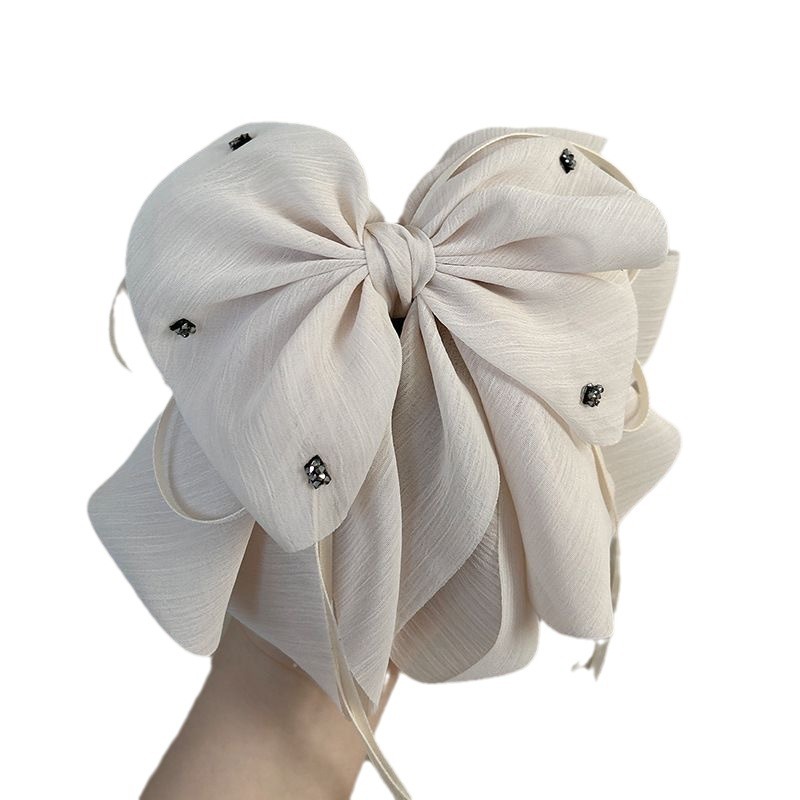 The elegant bow hair clip accentuates a woman's tall head. The ponytail hair clip exudes a sense of sophistication and grace. The half-tied hair is placed at the back of the head with a hair clip Item Picture