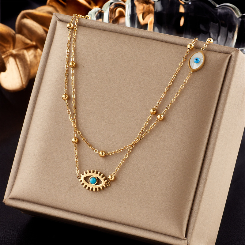 A double-layer mixed chain necklace with gold beads, titanium steel, oil-dripping and hollowed-out blue eyes, featuring a niche and fashionable design from Europe and America full figure