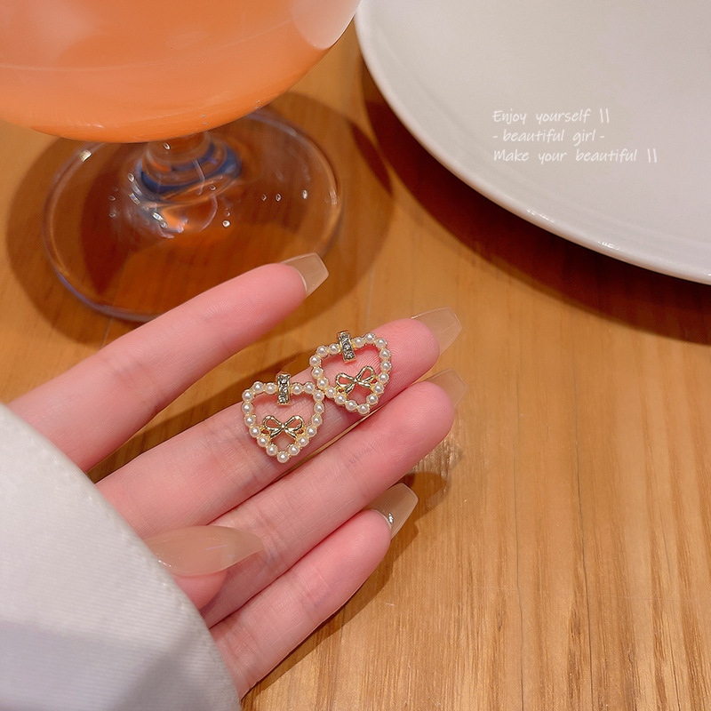 S925 Silver needle Korean new pearl heart-shaped earrings, women's light luxury style, versatile bow stud earrings wholesale full figure