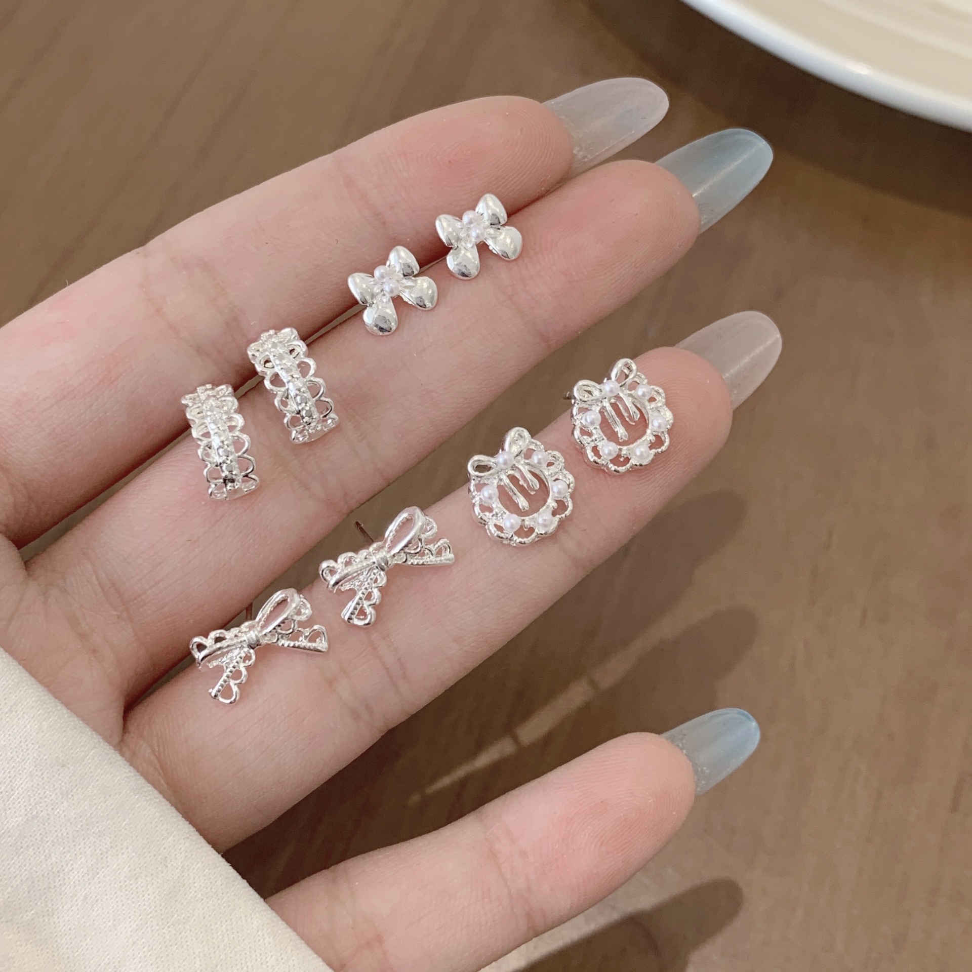 A three-piece set of Korean-style plain silver lace bow garland earrings with silver needles, featuring a fresh, niche and light luxury design details Picture