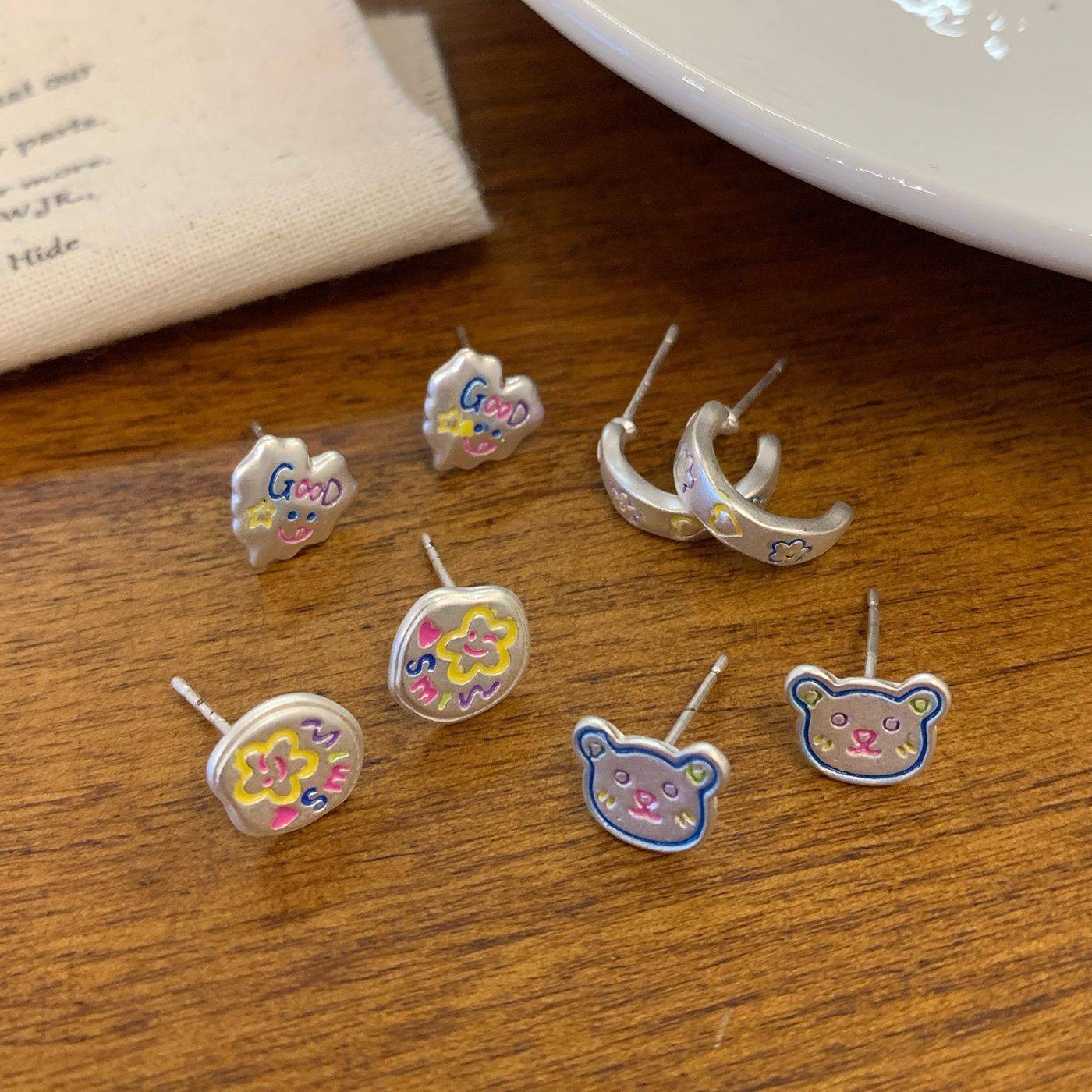 Spring 2025 Colorful hand-painted smiling face flower silver stud earrings, silver needle girl cartoon bear fun student earrings Application Scenario