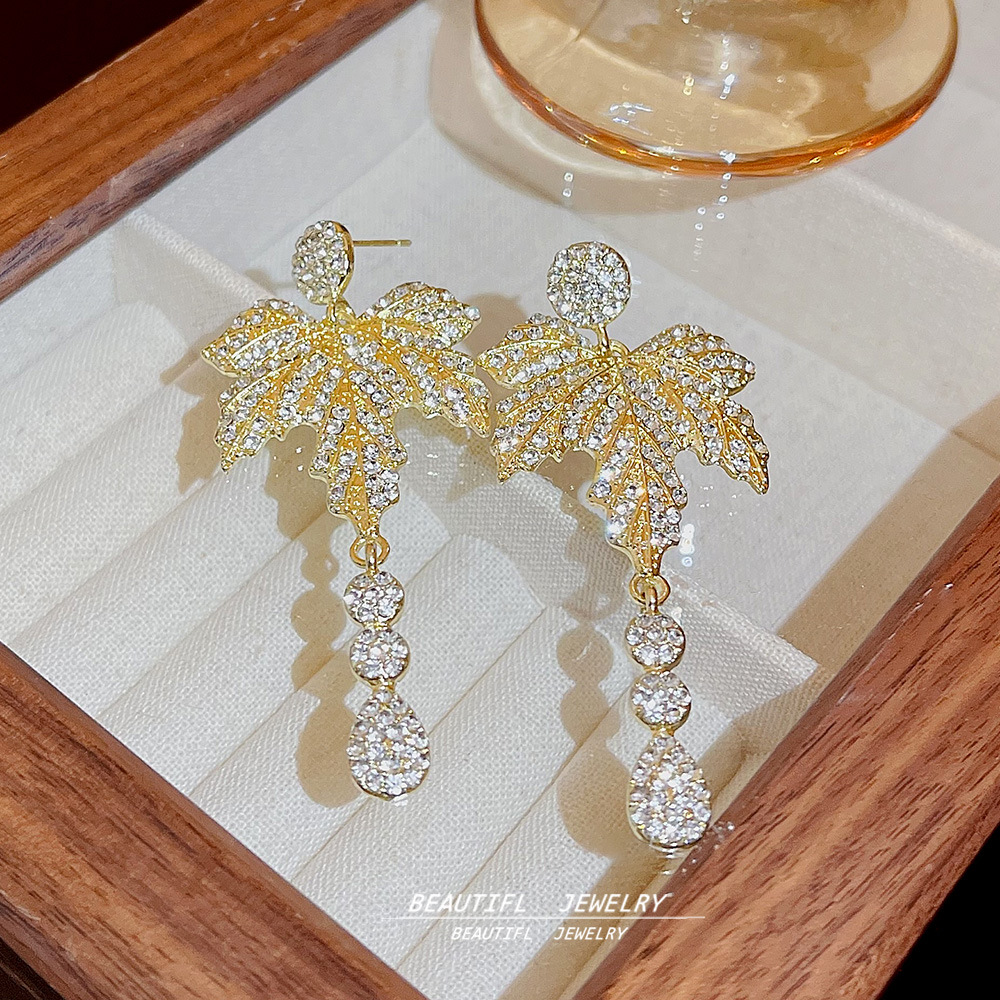 Wholesale of fashionable, long, elegant, and niche design maple leaf earrings with tassels, exuding a sense of sophistication and highlighting the face full figure