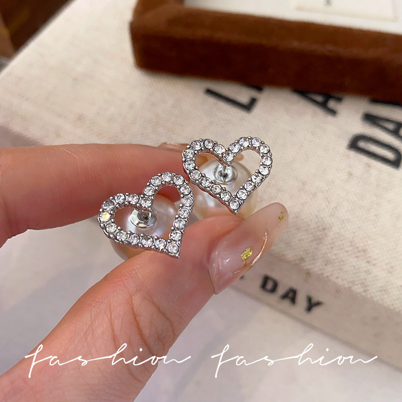 A pair of exquisite diamond heart-shaped stud earrings for women, exuding a light luxury and high-end feel. This is a unique design of heart-shaped earrings with two pearl earrings details Picture
