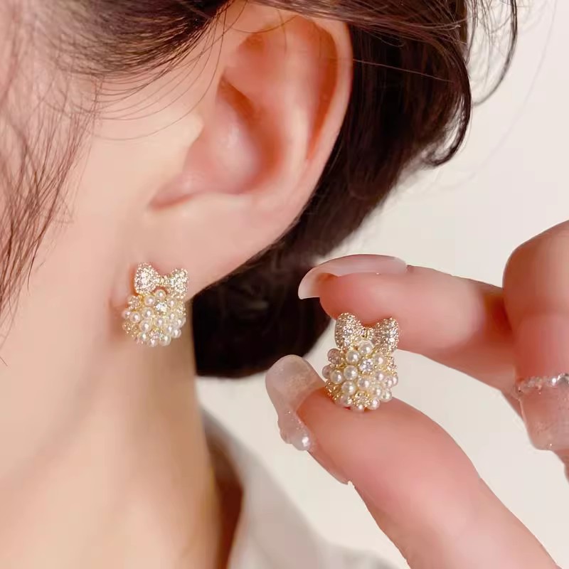 Japanese and Korean pearl bow earrings for women, a light luxury, fashionable and high-end look. The ear studs are a niche design, simple and versatile ear accessory full figure