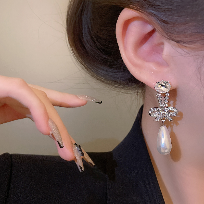 S925 Silver Needle Korean diamond-encrusted bow pearl Hundred-tower earrings, a fashionable, light luxury, individual and simple earpiece trend for women Application Scenario