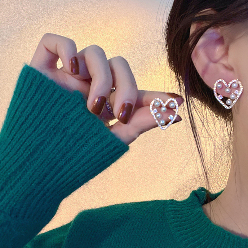 Wholesale of new autumn and winter heart-shaped hollowed-out pearl stud earrings for women, featuring a niche design sense, light luxury, individuality and versatility details Picture