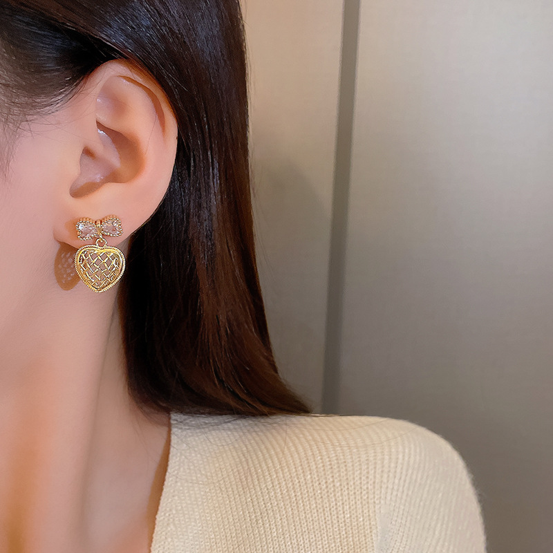 Wholesale of light luxury bow earrings with a sense of design, hollowed-out heart, elegant stud earrings and versatile earrings from Dongdaemun, South Korea details Picture