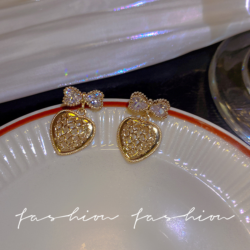 Wholesale of light luxury bow earrings with a sense of design, hollowed-out heart, elegant stud earrings and versatile earrings from Dongdaemun, South Korea full figure