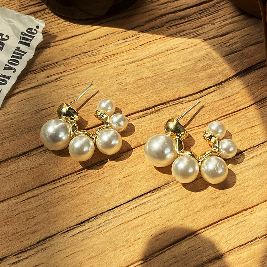 The popular imitation pearl ear rings on independent websites in Europe and America feature a creative, retro, unique and niche design of C-shaped letter earrings full figure