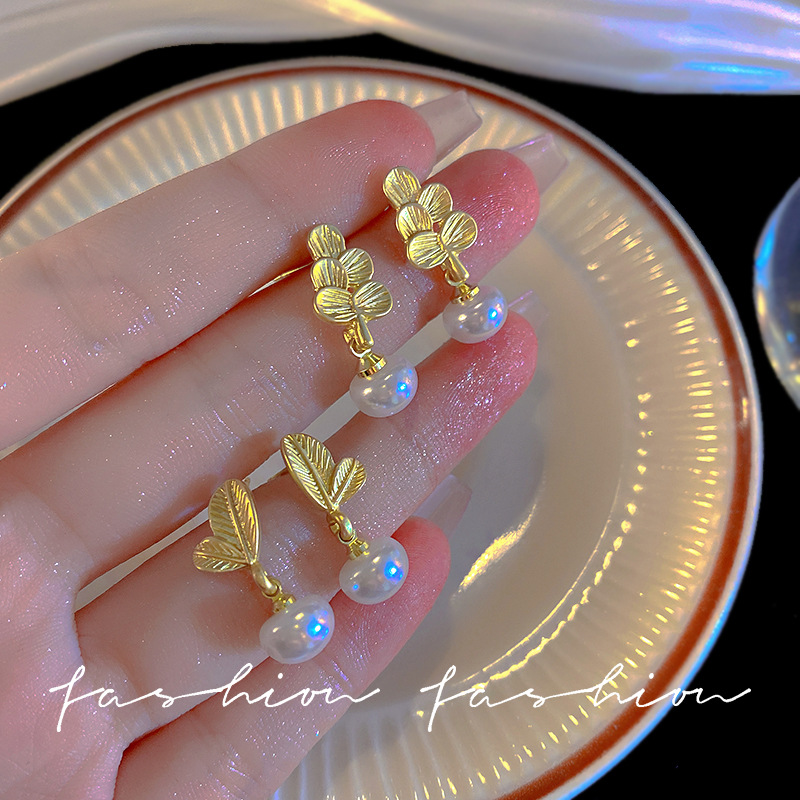 The minimalist forest-themed leaf pearl stud earrings are a new bestseller for women in 2023, featuring a simple and elegant style. They are light luxury earrings for a socialite full figure