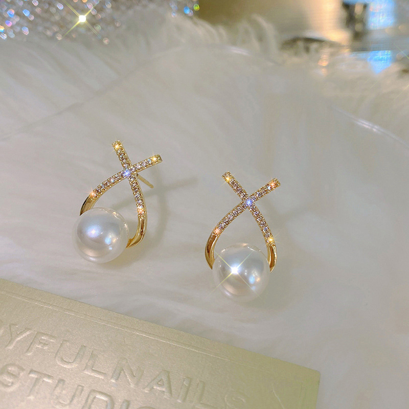 The new pearl stud earrings for women in 2023 feature a light luxury and niche design. The cross-shaped earrings are a French retro and versatile earpiece trend details Picture