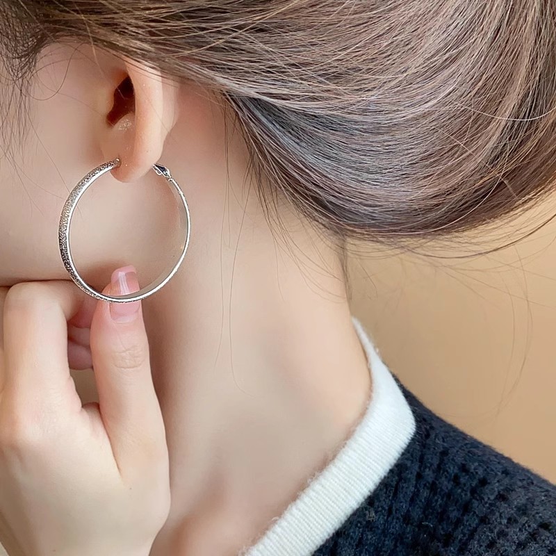The light luxury matte silver large ear rings exude a feminine charm and a sense of sophistication. The fashionable and exaggerated ear studs are simple and niche design earrings details Picture