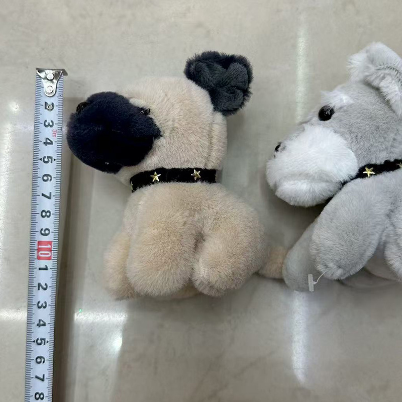 Plush keychains shaped like small animals arranged on a wooden board