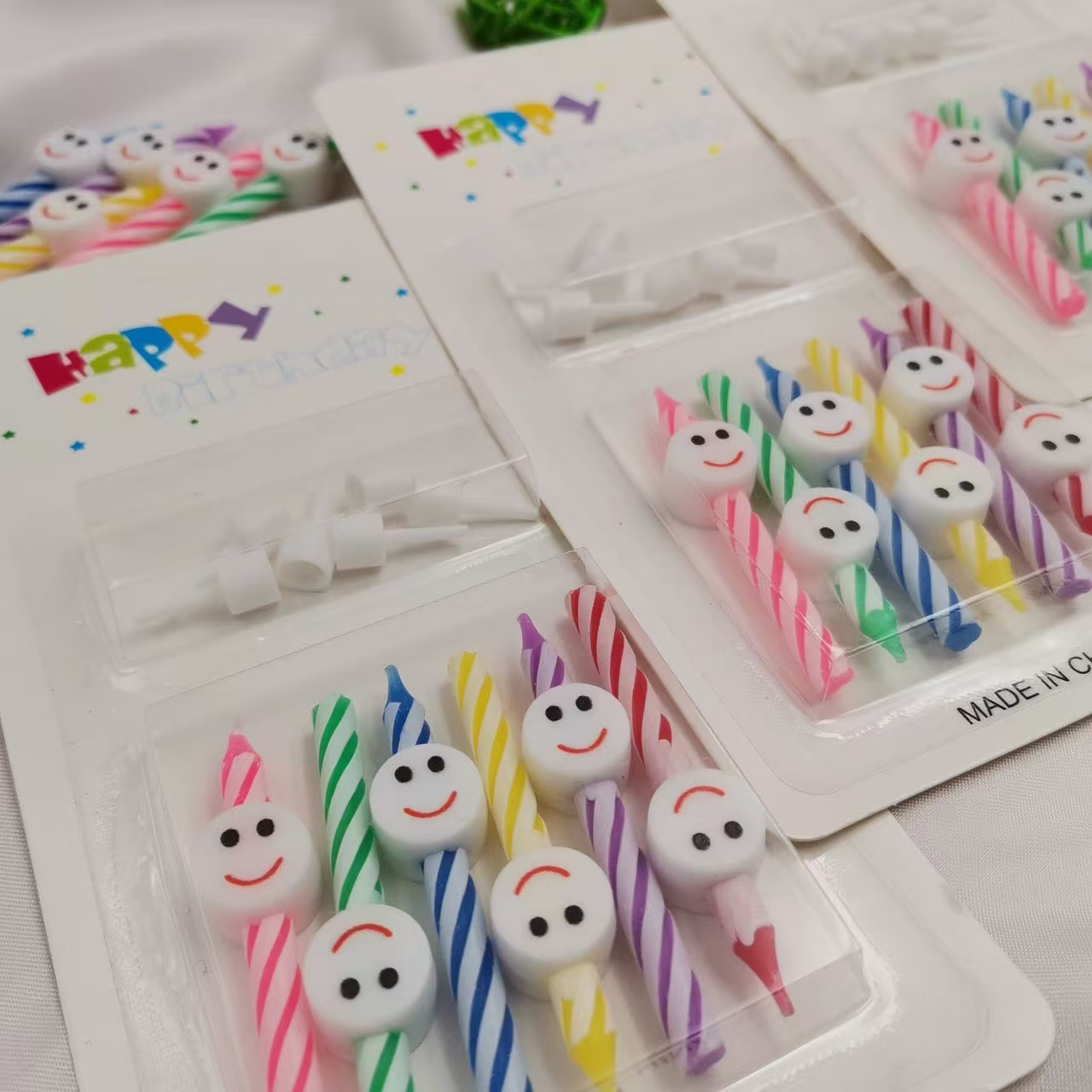Five heart-shaped, smiling candles, colorful candles, party supplies, and birthday celebration items. details Picture