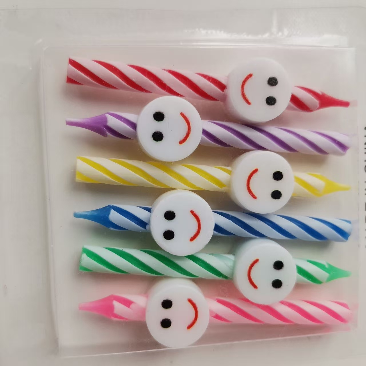 Five heart-shaped, smiling candles, colorful candles, party supplies, and birthday celebration items. Specification image