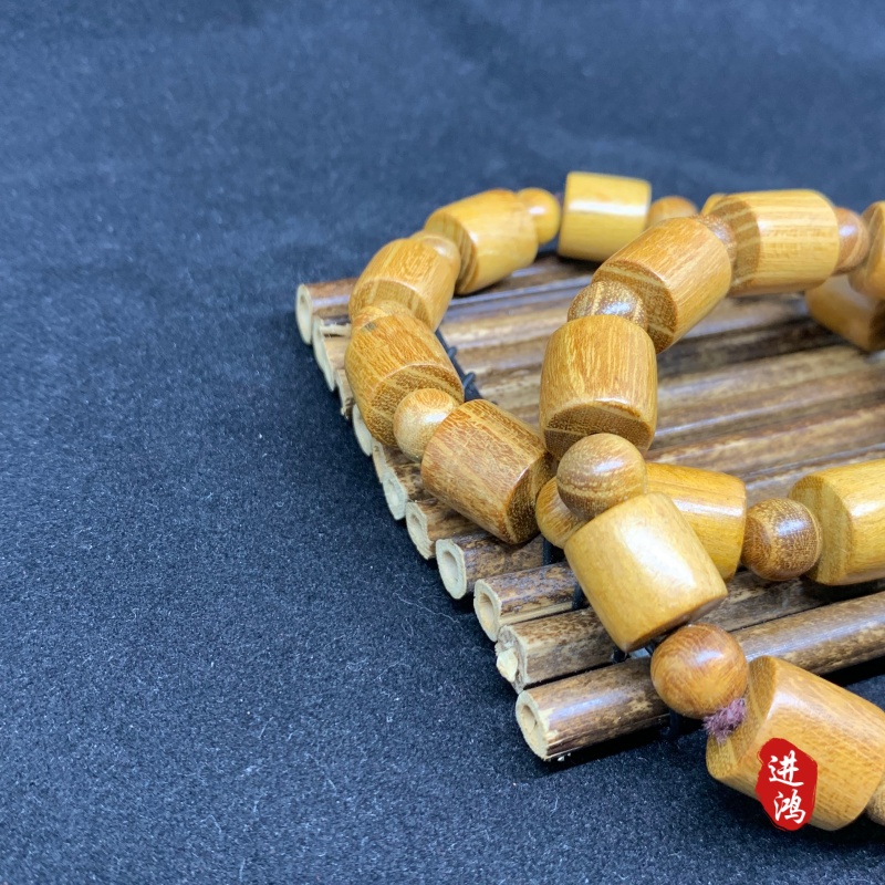 The new gold sandalwood bracelet in the bucket bead style is placed on a bamboo mat, presenting a simple and elegant look with its natural beauty fully displayed. Prayer beads 📿 cultural play bracelet prayer beads Specification image